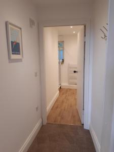 a hallway with white walls and wooden floors at Seasalt Loft in Barmouth