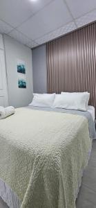 1 dormitorio con 1 cama grande con sábanas blancas en Los Corcho Suites Airport en Tapia Número Dos