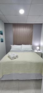 a bedroom with a large bed with towels on it at Suites Los Corcho Aeropuerto in Tapia Número Dos