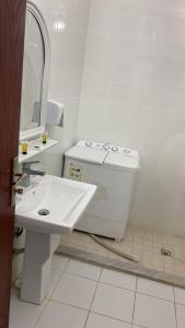 a white bathroom with a sink and a toilet at نجوم طابة الطيبة للشقق المخدومة in Al Jāmi‘ah
