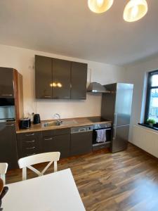 a kitchen with stainless steel appliances and wooden floors at Aurich City Loft in Aurich