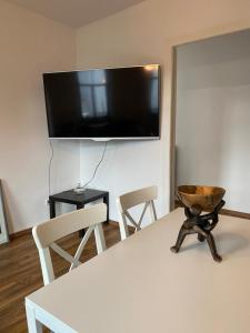 a room with a table with chairs and a tv on the wall at Aurich City Loft in Aurich
