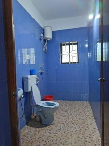 uma casa de banho azul com um WC e uma janela em THE OCEAN WAVE MORJIM em Morjim