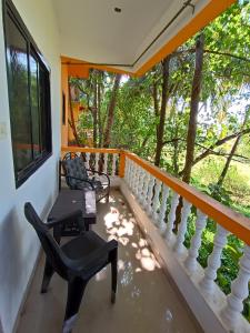 a balcony with a table and chairs and trees at THE OCEAN WAVE MORJIM in Morjim
