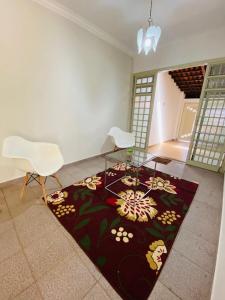 uma sala de estar com uma mesa de vidro e cadeiras brancas em Casa Comendador em Uberlândia