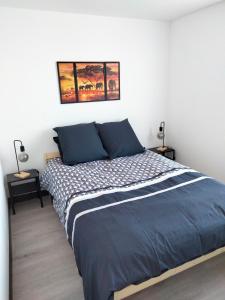 1 dormitorio con 1 cama grande con sábanas azules en L'ECUME, en Pléboulle
