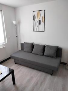 un sofá en una sala de estar con una foto en la pared en L'ECUME, en Pléboulle