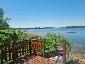 a wooden deck with a view of a lake at GARDENIA RAJGRÓD in Rajgród
