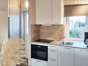 a kitchen with white cabinets and a sink and a window at 4 person holiday home in Gelting in Gelting