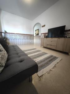 uma sala de estar com um sofá e uma televisão de ecrã plano em Village paradise em São Bartolomeu de Messines