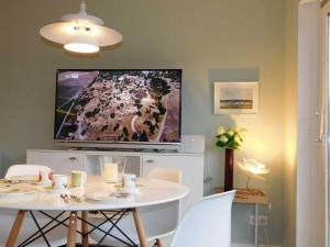 salon z białym stołem i telewizorem w obiekcie Rüm Hart I - apartment 2a Morirook w mieście Hörnum