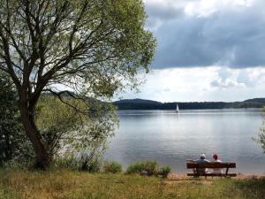 two people sitting on a bench overlooking a lake at Holiday apartment Sunflower in Marpingen
