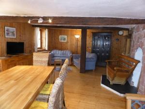 uma sala de estar com uma mesa de madeira e cadeiras em Holiday apartment on Breitenberg em Wilgartswiesen