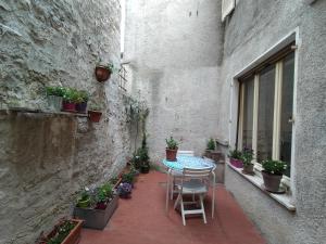 um pátio exterior com uma mesa, cadeiras e vasos de plantas em Il cortile di zia em Cagli