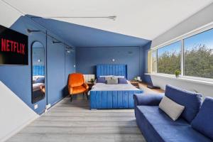 Dormitorio azul con cama y sofá en Cosy Retreat: Near Attractions & Comfortable!, en Birmingham