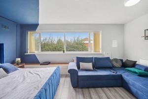 sala de estar con sofá azul y ventana en Cosy Retreat: Near Attractions & Comfortable!, en Birmingham