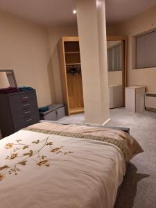 a bedroom with a bed and a dresser and a closet at Fabulous Home from Home - Central Long Eaton - Lovely Short-Stay Apartment - HIGH SPEED FIBRE OPTIC BROADBAND INTERNET - HIGH SPEED STREAMING POSSIBLE Suitable for working from home and students Very Spacious FREE PARKING nearby in Long Eaton
