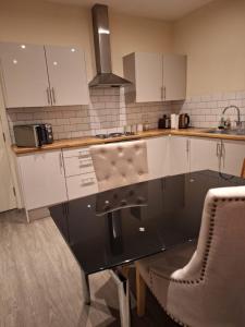 a kitchen with white cabinets and a counter top at Fabulous Home from Home - Central Long Eaton - Lovely Short-Stay Apartment - HIGH SPEED FIBRE OPTIC BROADBAND INTERNET - HIGH SPEED STREAMING POSSIBLE Suitable for working from home and students Very Spacious FREE PARKING nearby in Long Eaton