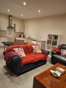 a living room with a couch with a red blanket at Fabulous Home from Home - Central Long Eaton - Lovely Short-Stay Apartment - HIGH SPEED FIBRE OPTIC BROADBAND INTERNET - HIGH SPEED STREAMING POSSIBLE Suitable for working from home and students Very Spacious FREE PARKING nearby in Long Eaton