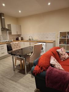 Fabulous Home from Home - Central Long Eaton - Lovely Short-Stay Apartment - HIGH SPEED FIBRE OPTIC BROADBAND INTERNET - HIGH SPEED STREAMING POSSIBLE Suitable for working from home and students Very Spacious FREE PARKING nearby في لونغ إيتون: غرفة معيشة مع أريكة وطاولة في مطبخ