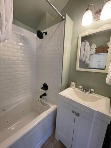 a bathroom with a white tub and a sink and a bath tub at Pet Friendly 2 BR House in Southwest Harbor! [Hillside Cottage] in Southwest Harbor