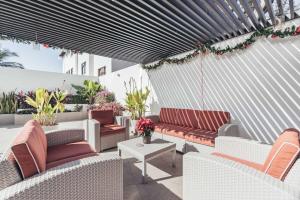 eine Terrasse mit Sofas und einem Tisch mit Blumen in der Unterkunft DellaTerra-1-PV 1st Floor in Bucerías