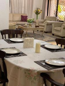un soggiorno con tavolo, sedie e piatti di Beautiful & Cozy Newly remodeled 2 Bedroom ad Amman