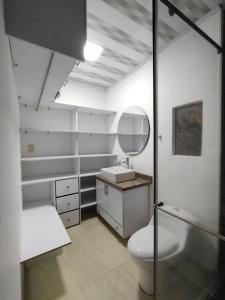 a bathroom with a toilet and a sink and a mirror at Casa La Riviera in Santa Rosa de Cabal