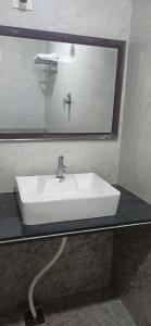 蒂鲁帕蒂Kuber Residency的浴室里有一面镜子的白色水槽