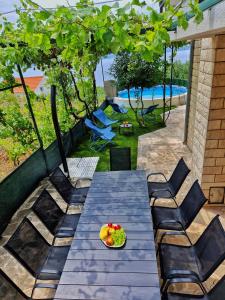 - une table et des chaises avec un bol de fruits sur la terrasse dans l'établissement Holiday Home Omindula, à Jesenice