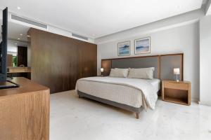 a bedroom with a bed and a dresser with a television at 03 F2 Bolongo-PV in Punta Mita +84 photos