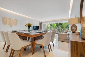 a dining room with a wooden table and white chairs at 03 F2 Bolongo-PV in Punta Mita