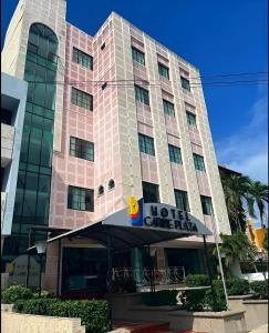 duży różowy budynek z hotelem w obiekcie Hotel Caribe Plaza Barranquilla w mieście Barranquilla