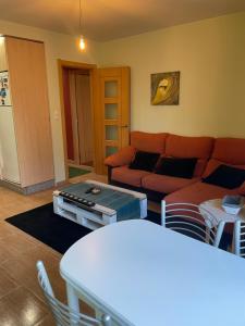 een woonkamer met een bank en een tafel bij Apartamento luminoso y acogedor in Lalín