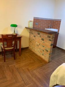 Habitación con chimenea de ladrillo, mesa y silla. en Apart Hotel El Doral en Lima