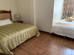 Schlafzimmer mit einem Bett und Holzboden in der Unterkunft Apart Hotel El Doral in Lima