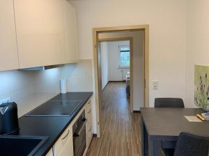 a kitchen with a black counter top and a hallway at BestBoarding24 in Schöllkrippen