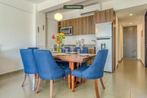 een keuken met een houten tafel en blauwe stoelen bij Amazing Condo with Pool in Nuevo Vallarta 