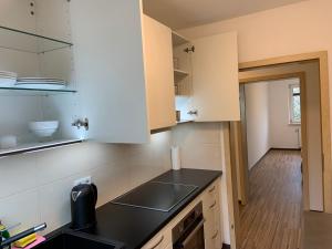 a kitchen with white cabinets and a black counter top at BestBoarding24 in Schöllkrippen