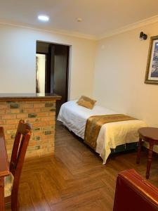 1 dormitorio con 1 cama y 1 mesa en una habitación en Apart Hotel El Doral, en Lima