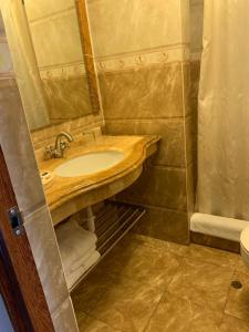 y baño con lavabo y espejo. en Apart Hotel El Doral, en Lima