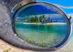 a view of an island in the ocean through a mirror at Ninamu Resort in Tikehau