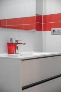 a kitchen with red and white walls and a sink at Casa More Alcalá Center in Alcalá +15 photos
