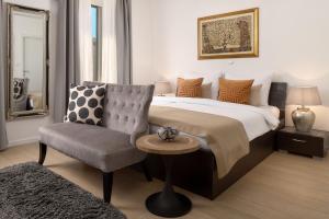 a bedroom with a king sized bed and a chair at Apartments Studios 81 in Split