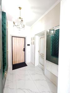 a hallway with a door and a chandelier at ЖК ATREA 2 room Apartment in Almaty