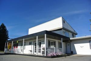 海登Silver Lakes Inn的一栋带有门廊和车库的白色建筑