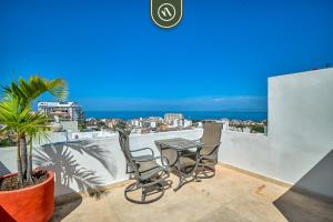 einen Tisch und Stühle auf einem Balkon mit Meerblick in der Unterkunft Sonnrisa Condominums 1 in Puerto Vallarta