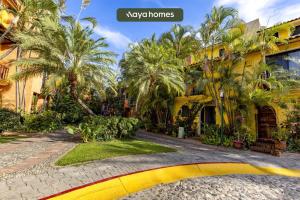 une maison jaune avec des palmiers et une rue dans l'établissement Cozy 3BR House - Front of Marina - Pool, à Puerto Vallarta