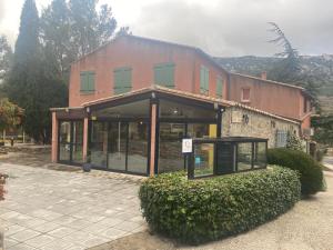 un grand bâtiment avec beaucoup de fenêtres dans l'établissement Auberge la Table du Curé, à Cucugnan