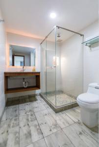 y baño con ducha de cristal y aseo. en Hotel Casa Botero 201, en Bogotá
